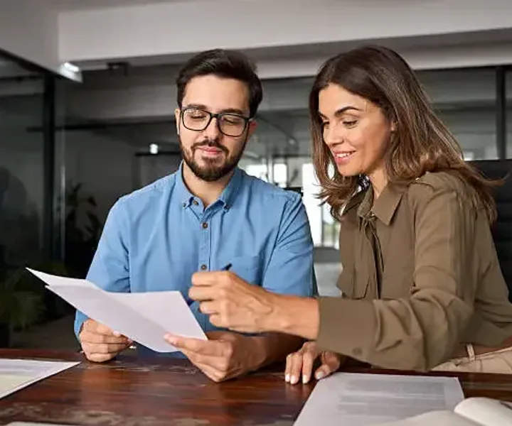 Two colleagues going through a document together at a desk