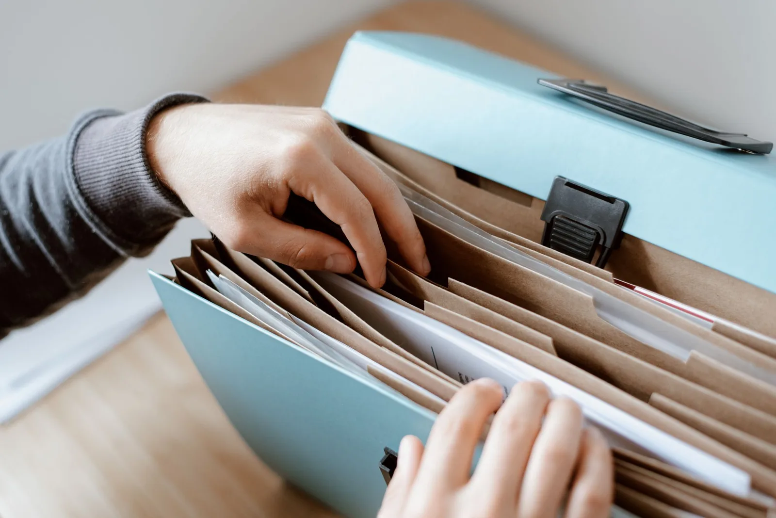 Hands sorting papers in a document folder