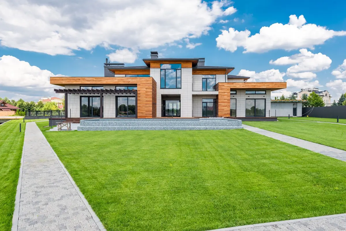 Contemporary residential property with large windows and a green lawn