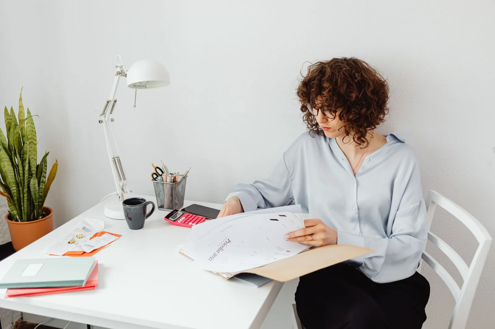 Woman reviewing documents at a desk at home