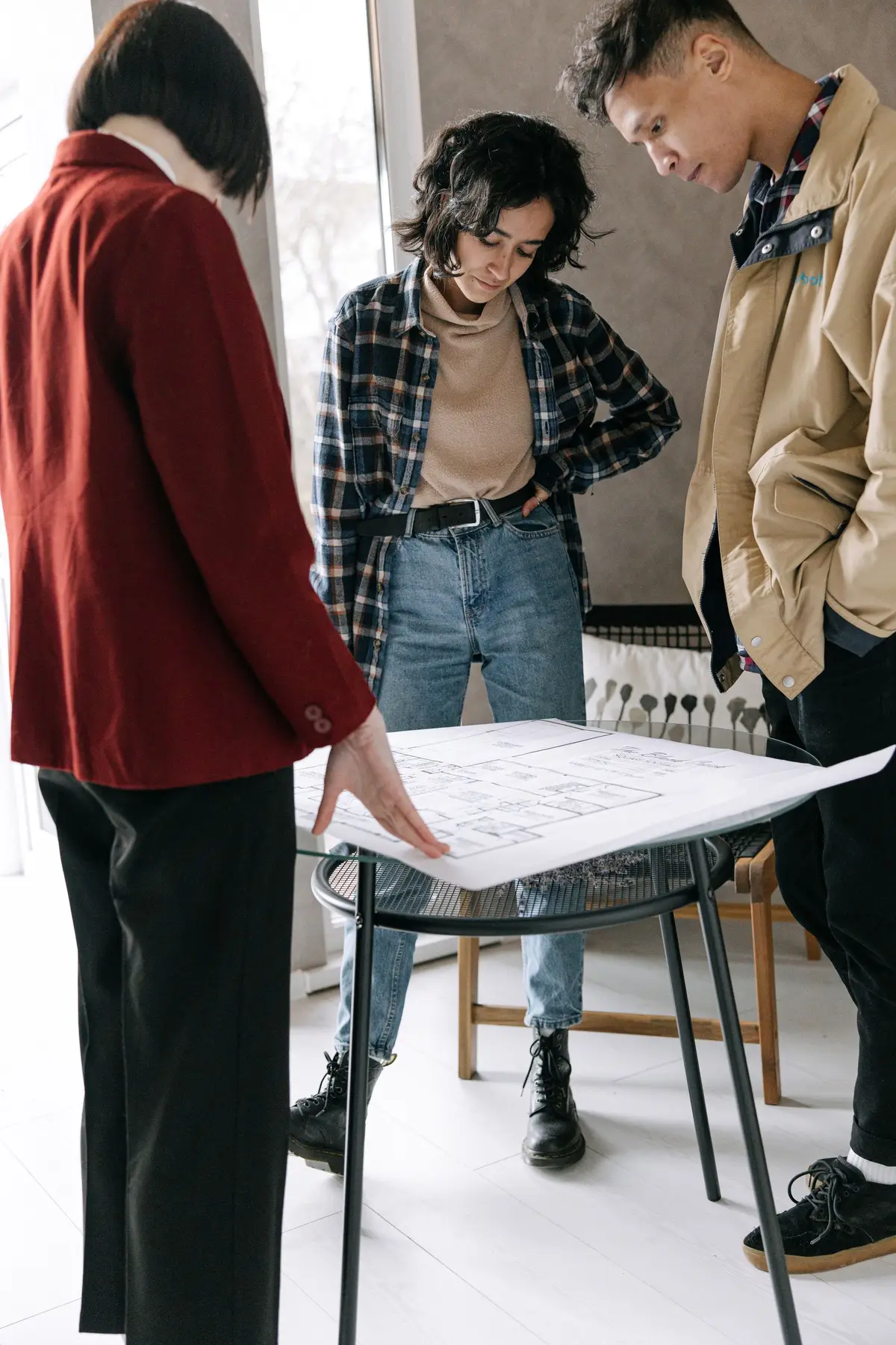 A couple and property professional reviewing house plans